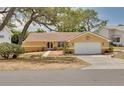 A beautifully landscaped single-Gathering home featuring a terra cotta roof and an attached two-car garage at 315 Ridge Rd, Palm Harbor, FL 34683