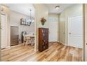 Open hallway leading to a dining nook and the front entrance offering wood-look floors and a glimpse of the interior design at 3205 Audubon Ct, Tarpon Springs, FL 34688