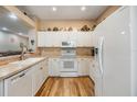 Bright kitchen with white cabinets, countertops, and wood-look flooring, providing a clean and modern cooking space at 3205 Audubon Ct, Tarpon Springs, FL 34688