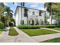 Stunning exterior view showcasing a white stucco home with well-manicured lawn, private drive and lush greenery at 3212 W Fountain Blvd, Tampa, FL 33609