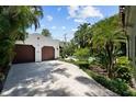 Detached two-car garage with lush landscaping, a view of the pool, and a sunny sky at 3212 W Fountain Blvd, Tampa, FL 33609
