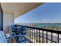 Relaxing condo balcony with Adirondack chairs and table overlooking panoramic waterfront views and cityscape at 400 Island Way # 1709, Clearwater Beach, FL 33767