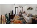 Open-concept living room with neutral sofa, TV, decorative rug, and ample natural light at 4108 N Thatcher, Tampa, FL 33614
