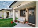 Inviting porch with a cozy wicker sofa, plants, and stylish details, creating a welcoming entrance at 4108 N Thatcher, Tampa, FL 33614