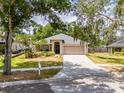Inviting single-story home featuring a manicured lawn, mature trees, and convenient driveway at 412 Henderson Ave, Seffner, FL 33584
