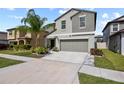 Two story home with a two car garage, beautiful landscaping and a palm tree in the front yard at 4533 Eternal Prince Dr, Sun City Center, FL 33573