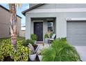 Charming front entrance featuring a black door, muted siding, and lush landscaping at 4533 Eternal Prince Dr, Sun City Center, FL 33573