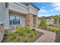 Inviting front porch with stone columns, comfortable seating, and lush landscaping, creating a welcoming entrance at 4831 Rosatti Rd, Wesley Chapel, FL 33543