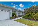 Exterior view of a single-story home, showcasing manicured landscaping and neutral paint at 5193 Boyle Ter, Port Charlotte, FL 33981