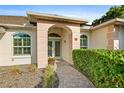 Elegant front entrance with arched doorway, brick path, and manicured landscaping at 5296 Slater Rd, Spring Hill, FL 34608