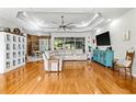 Spacious living room with hardwood floors, ceiling fan, and modern entertainment center at 5296 Slater Rd, Spring Hill, FL 34608