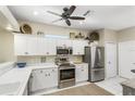 Bright kitchen features white cabinets, stainless steel appliances, and modern fixtures at 7253 Cleopatra Dr, Land O Lakes, FL 34637