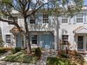 Charming townhouse featuring light blue shutters, complemented by lush greenery and a mature tree at 8612 Hunters Key Cir, Tampa, FL 33647