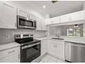 Well-lit, upgraded kitchen with modern stainless steel appliances, white cabinetry, and bright countertops at 8612 Hunters Key Cir, Tampa, FL 33647