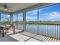 Relax on the screened patio with stunning lake views and a dining set, ideal for outdoor living at 915 Tidewater Shores Loop, Bradenton, FL 34208