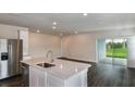 Open kitchen with an island, stainless steel appliances, and a view into the living area at 10516 Hidden Banks Gln, Parrish, FL 34219