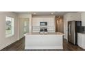 Bright kitchen with an island, stainless steel appliances, and white cabinets providing a modern, functional design at 10516 Hidden Banks Gln, Parrish, FL 34219