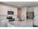 Modern kitchen featuring stainless steel appliances, white cabinetry, and a center island with countertop space at 10516 Hidden Banks Gln, Parrish, FL 34219