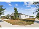 Well-manicured lawn surrounds this charming single-story home with easy access to the neighborhood sidewalk at 10628 Massimo Dr, Wimauma, FL 33598