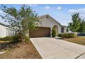 Charming single-story home featuring a spacious driveway and a beautifully landscaped front yard at 10628 Massimo Dr, Wimauma, FL 33598