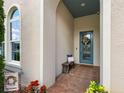 A charming, covered front porch with brick flooring, a bench, and a beautifully decorated front door at 1104 Isobel Reserve Ln, Tampa, FL 33613