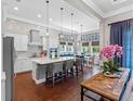 A modern kitchen with a large island, stylish pendant lighting, and stainless steel appliances at 1104 Isobel Reserve Ln, Tampa, FL 33613
