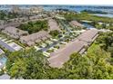 Scenic aerial view of a condo community with lush landscaping, serene pond, and glimpses of the bay at 11162 Kapok Grand Cir, Madeira Beach, FL 33708