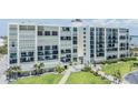 Beautiful exterior of a beachfront condo with balconies, lush landscaping, and walking paths at 1400 Gulf Blvd # 306, Clearwater Beach, FL 33767