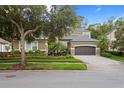 Beautiful home with lush landscaping, brick driveway, and a well-maintained front yard at 14851 Tudor Chase Dr, Tampa, FL 33626
