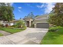 Charming exterior view with brick driveway and mature landscaping, showcasing curb appeal at 14851 Tudor Chase Dr, Tampa, FL 33626