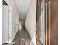 Inviting hallway features stylish dark floors and provides an open view to the light-filled living spaces beyond at 16519 Us Highway 41, Spring Hill, FL 34610