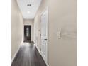 Neutral hallway features modern wood-look floors, recessed lighting, and access to various rooms throughout the home at 16519 Us Highway 41, Spring Hill, FL 34610