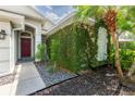 Stylish front entry featuring a red door and mature greenery on the facade at 2008 Berry Lake Dr, Brandon, FL 33510