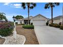 Charming home with well-manicured landscaping and a spacious two-car garage, complemented by lush palm trees at 2258 Preservation Green Ct, Sun City Center, FL 33573