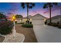 Twilight view of home, complemented by lush palm trees and manicured landscaping with a cozy curb appeal at 2258 Preservation Green Ct, Sun City Center, FL 33573