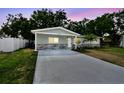 Inviting single-story home featuring a freshly painted driveway and serene landscaping at 3106 Ash Ct, Dunedin, FL 34698
