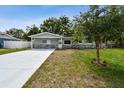 Beautifully renovated single-story home with modern exterior paint, stone accents, and a well-kept lawn at 3106 Ash Ct, Dunedin, FL 34698