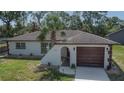 An inviting home showcasing clean lines, a tile roof, and a well-manicured lawn, set in a serene neighborhood at 3344 Blythe Ave, Spring Hill, FL 34609