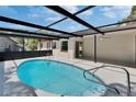 Screened-in pool featuring a refreshing, turquoise water and black metal enclosure in a backyard setting at 3344 Blythe Ave, Spring Hill, FL 34609
