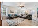 Cozy living room with neutral carpet, ceiling fan, and lots of natural light at 3876 Crossline Dr, Spring Hill, FL 34609