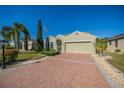 Inviting home with a brick driveway and lush landscaping at 445 Noble Faire Dr, Sun City Center, FL 33573