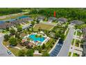 Aerial view of a home, community pool, and green space in a beautiful neighborhood at 4551 Barletta Ct, Wesley Chapel, FL 33543