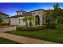 Charming two-story home at dusk, with landscaped yard at 4551 Barletta Ct, Wesley Chapel, FL 33543