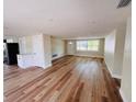 Open-concept living area with wood floors, bright natural light, and a view of the entryway at 6046 7Th Ave, New Port Richey, FL 34653