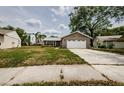 Exterior view of the one-story house with a two-car garage and a driveway leading up to the front at 7763 Jenner Ave, New Port Richey, FL 34655