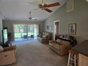 Inviting living room featuring plush furniture, a ceiling fan, and sliding glass doors to the backyard at 827 Creekside Ln, Palm Harbor, FL 34684