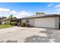 A charming home boasts a two-car garage and a spacious driveway on a sunny day with blue skies at 916 Shangri La Dr, Seffner, FL 33584
