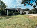 Charming single story home with stone accents, a screened porch, and a well manicured lawn at 916 Shangri La Dr, Seffner, FL 33584