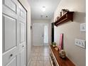 Inviting foyer with tile flooring, coat closet, and convenient shelf at 12125 71St Way, Largo, FL 33773