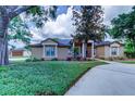 Charming single-story home featuring a well-manicured lawn and an inviting front entrance at 15302 Lake Maurine Dr, Odessa, FL 33556